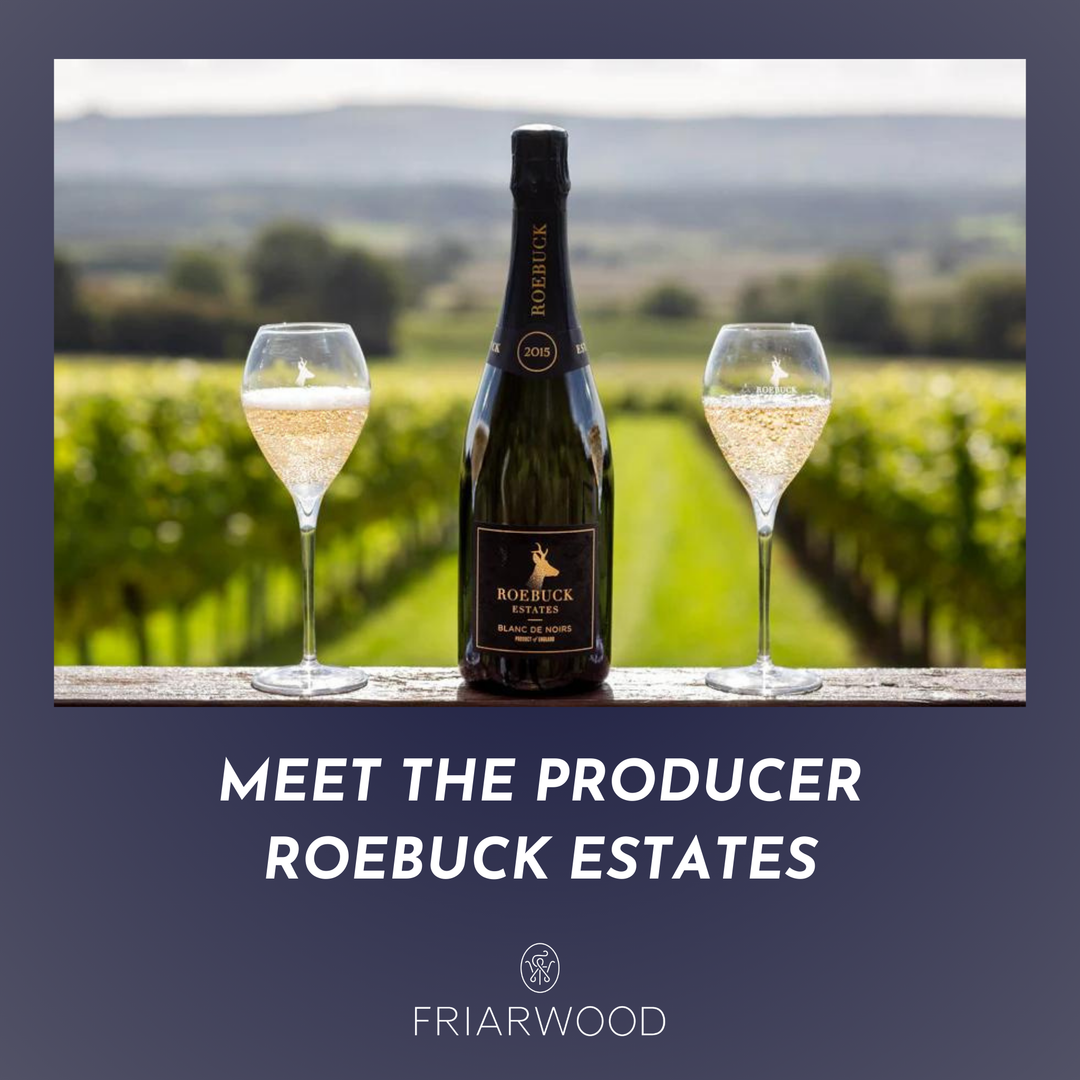 Bottle of Roebuck Estates wine with two glasses in a vineyard setting, featuring Friarwood branding.