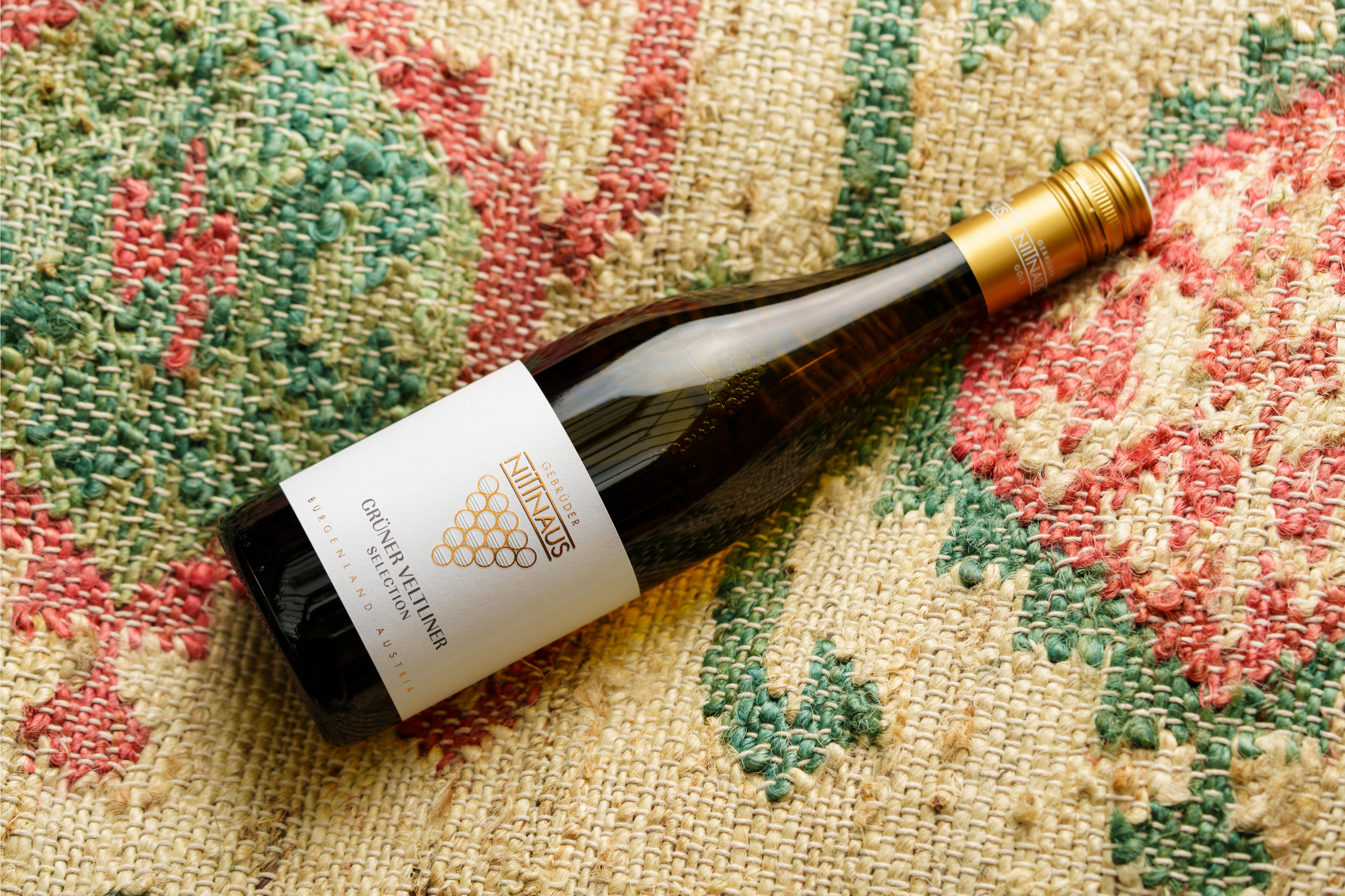 Bottle of Nittnaus Grüner Veltliner Selection 2020 placed on a textured woven fabric background.