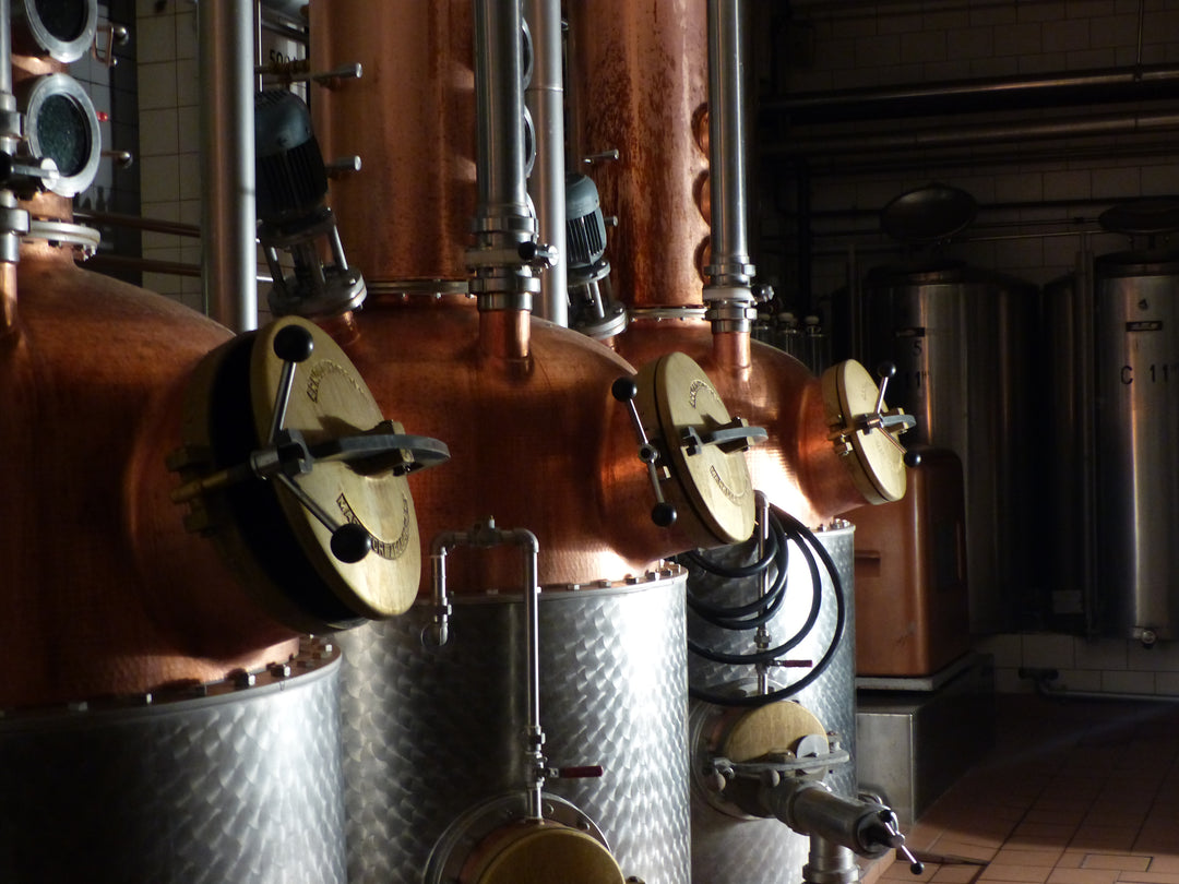Copper stills in a distillery setting