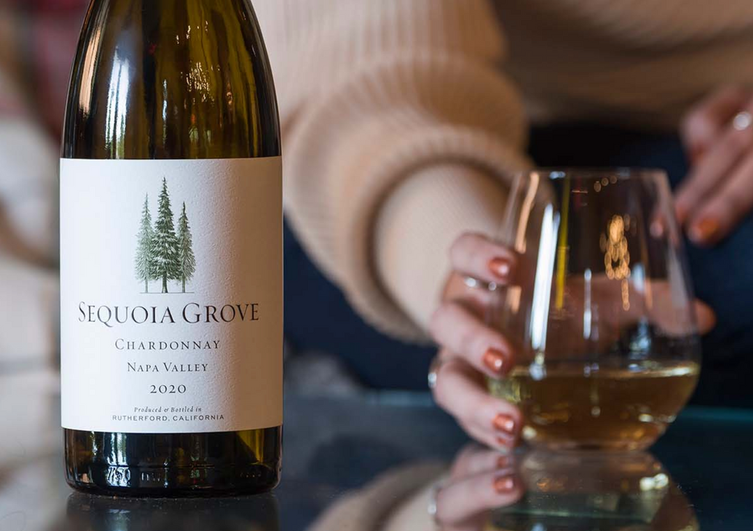 Bottle of Sequoia Grove Chardonnay 2020 Napa Valley with a glass of white wine in hand.