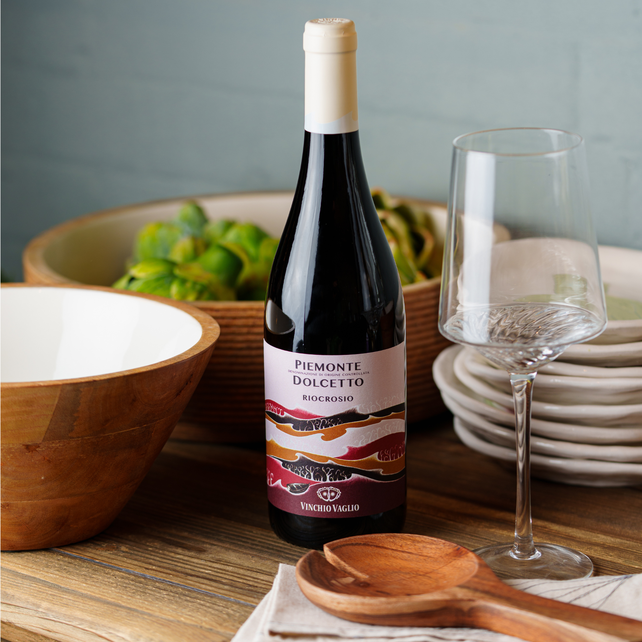 Vinchio Vaglio Piemonte Dolcetto Riocrosio bottle on a wooden kitchen counter beside bowls and glassware